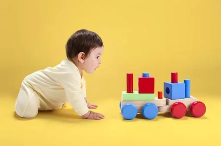 Bebê com brinquedo de madeira